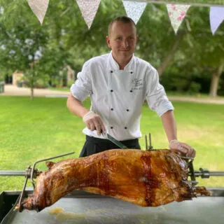All-Events-hog-Roast-Pig-1 - All Events Hog Roast Spit Roast Chef Cutting into Crackling on hog roast Meat joint roasted on spit roast bbq