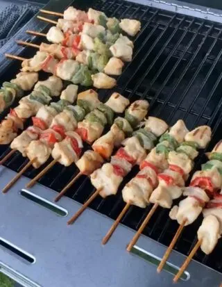 BBQ chicken and pork skewers with peppers cooking on BBQ grill