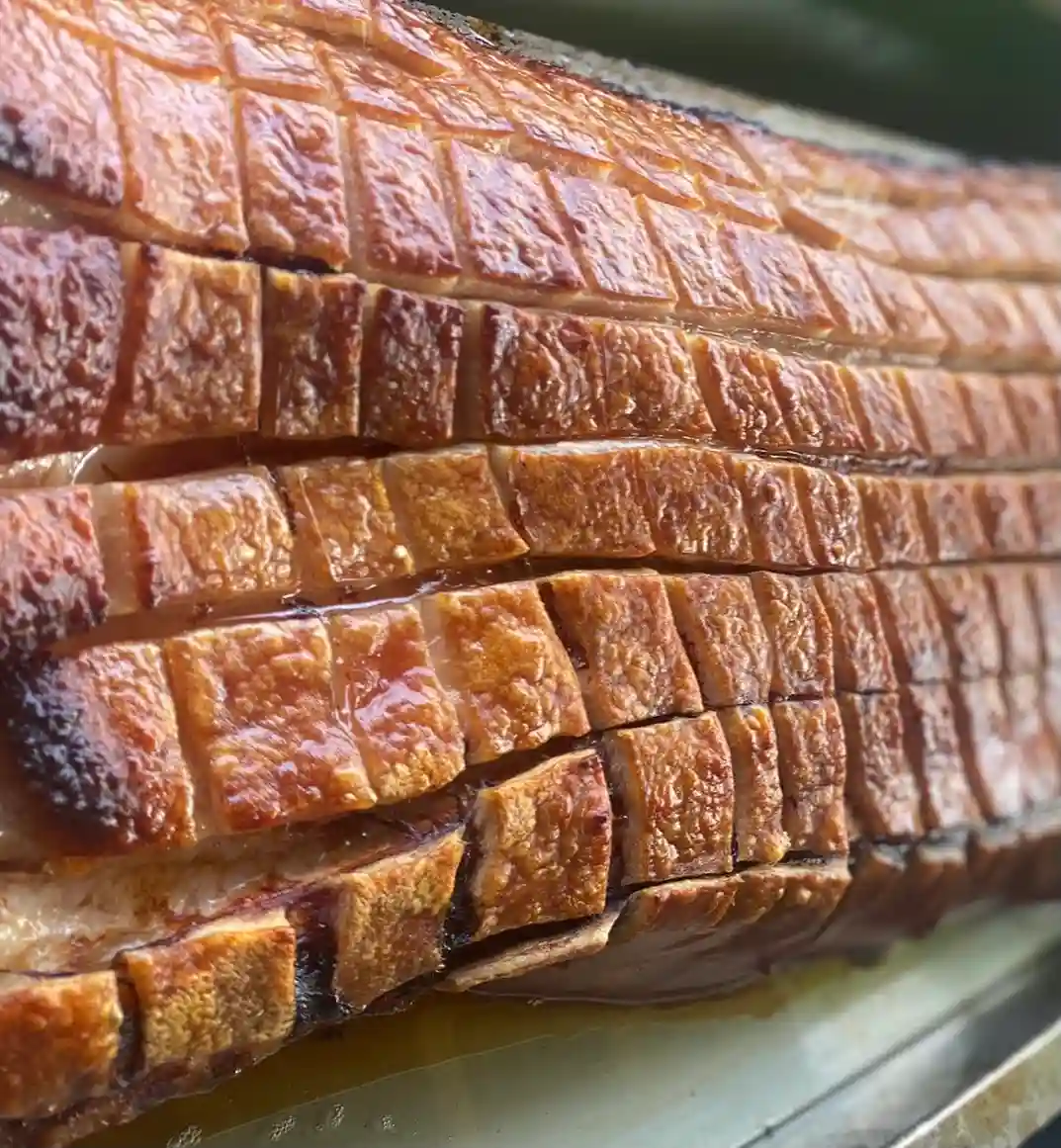 Mouthwatering crackling on Meat joint roasted on spit roast bbq